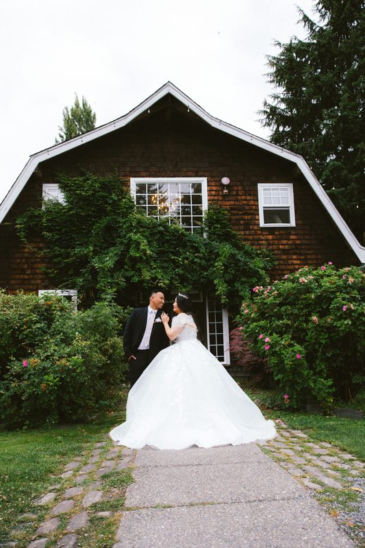 Couple in front of a vine-covered barn