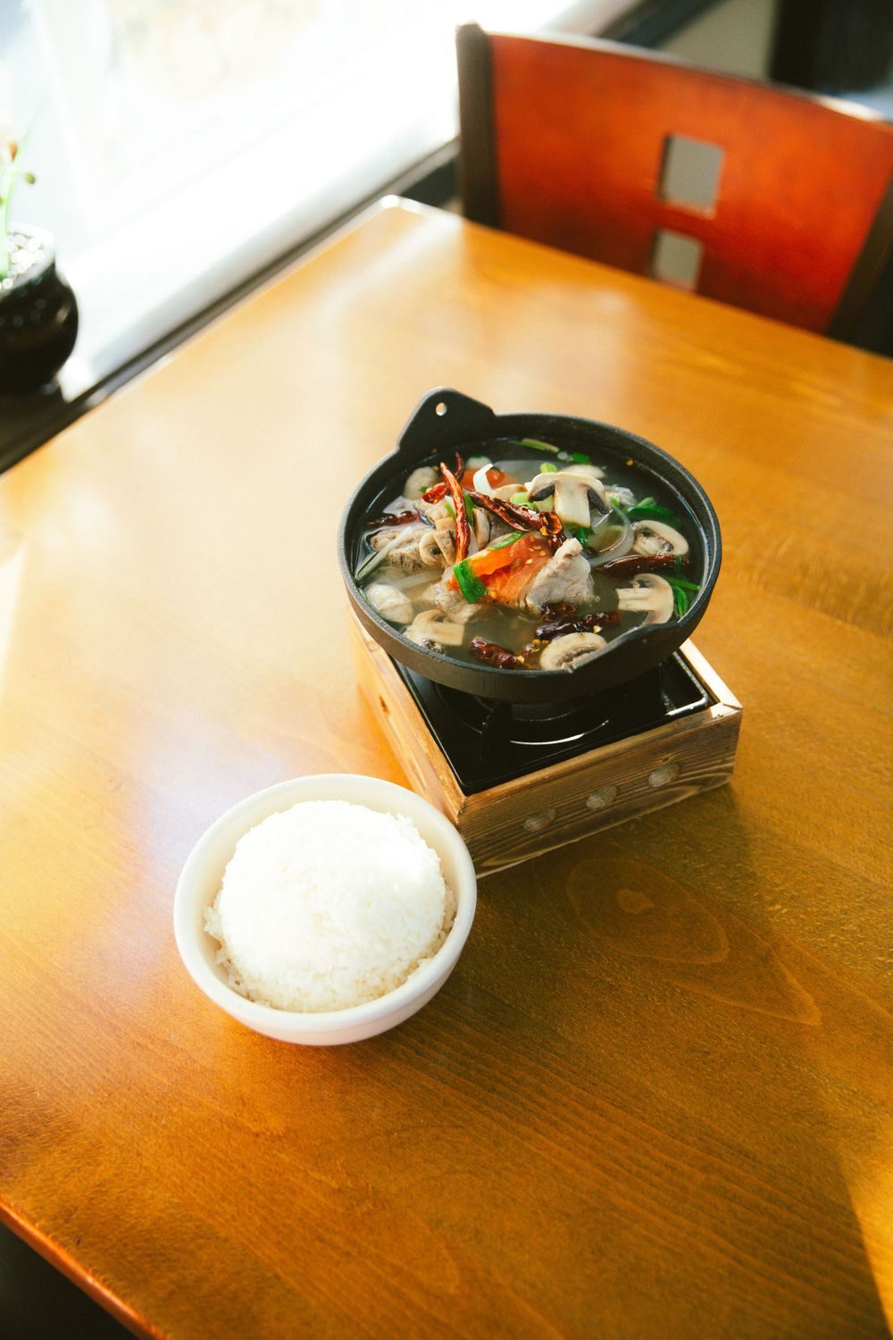 Hot pot and rice on a wooden table