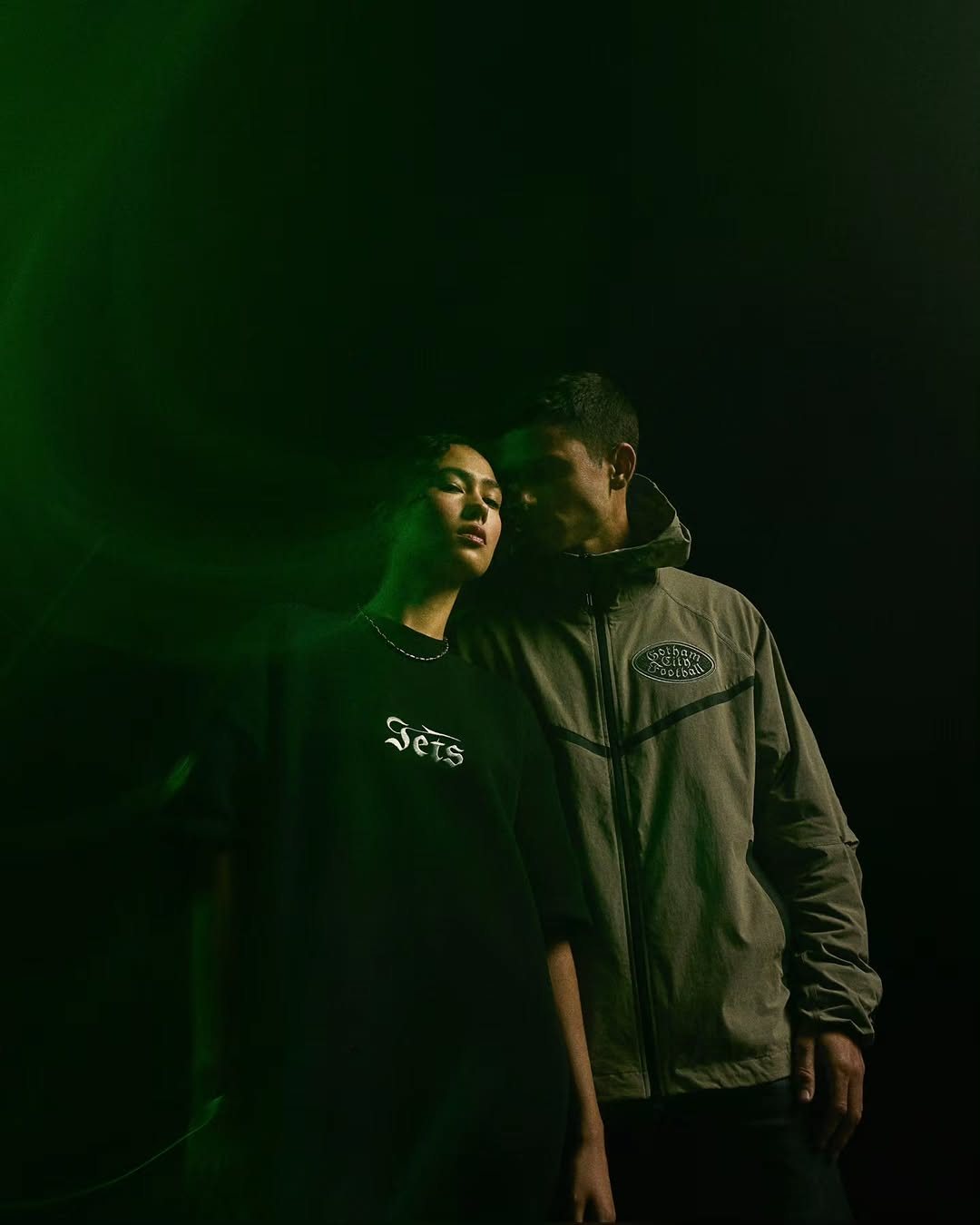 Couple in Jets jackets in green light