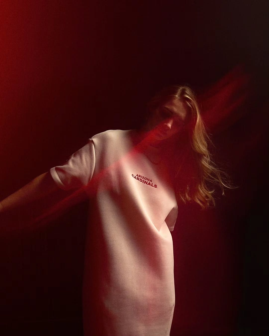 Woman in a Cardinals sweatshirt with red light trails