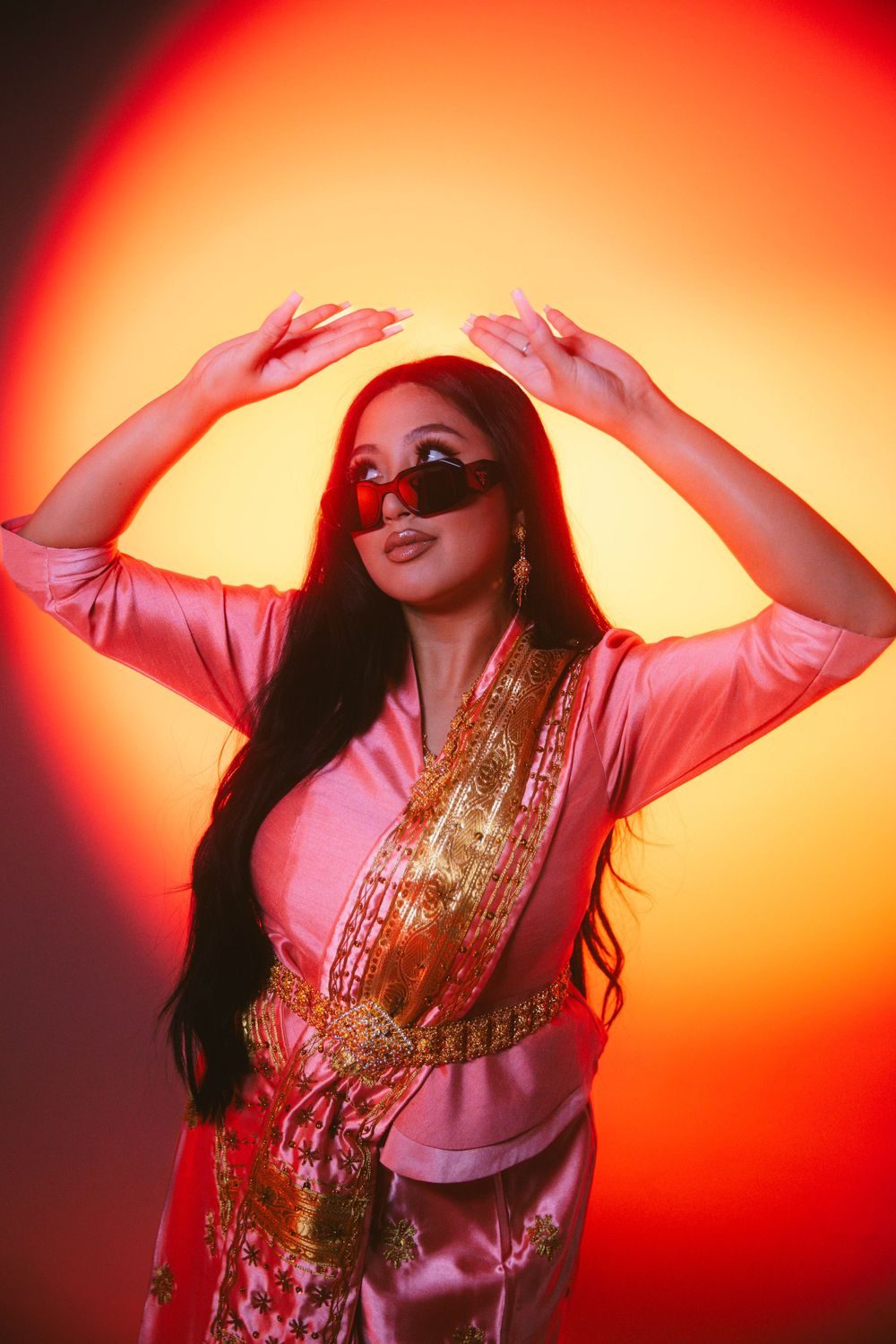 Woman in sunglasses under a red and orange glow